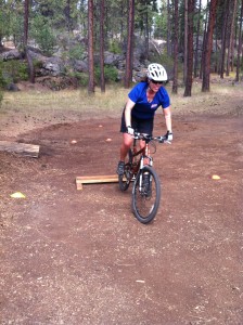 A student practicing front wheel lifts during a biking class.
