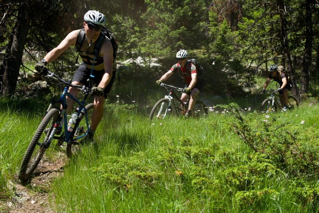 Three Mountain Bikers Drop into Narrow Singletrack